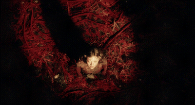 Girl In Red Dress Surrounded By Red Branches GIF