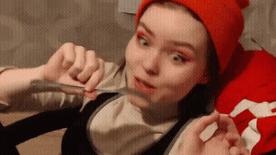 Girl In Red Hat Holding Spoon To Mouth GIF
