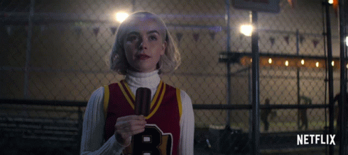 Girl In Red Jersey With Letter B Holding Microphone GIF