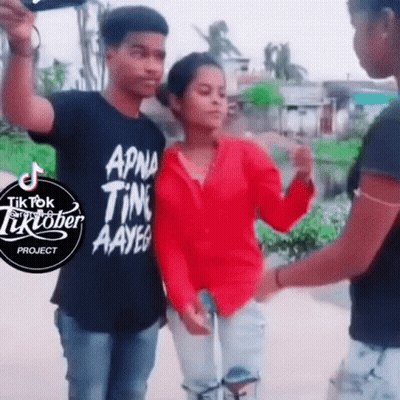 Girl In Red Shirt Next To Man In Black Shirt Saying TikTok GIF