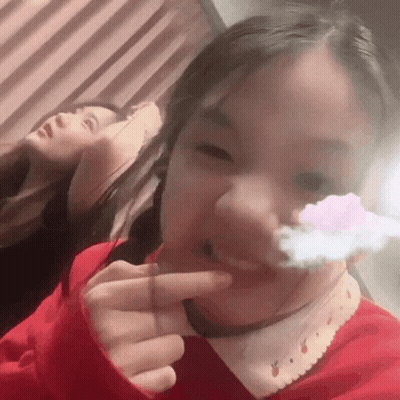 Girl In Red Sweater Making Funny Face With Finger In Mouth GIF