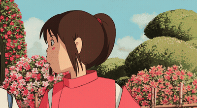 Girl In Red Sweater Standing In Front Of Pink Flowers GIF