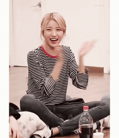 Girl In Striped Shirt Sitting Cross-Legged With Coke GIF