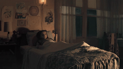 Girl In Striped Shirt Sitting On Bed GIF