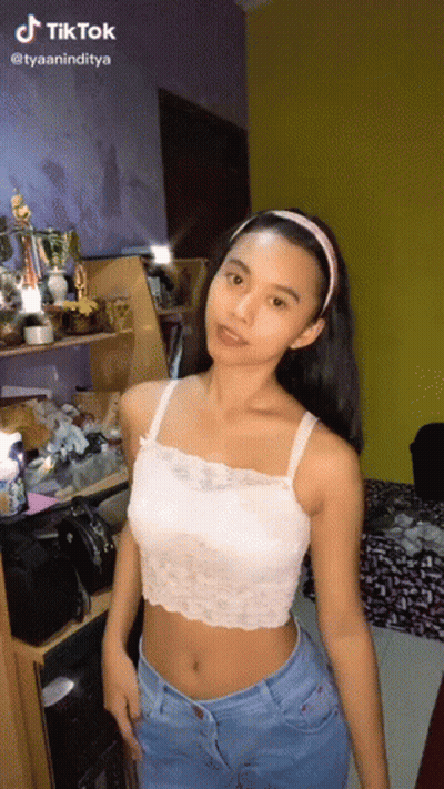 Girl In White Crop Top And Blue Jeans Standing In Room GIF