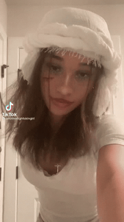 Girl In White Hat With Cross On Neck GIF