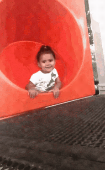 Girl In White Shirt Going Down Orange Slide GIF