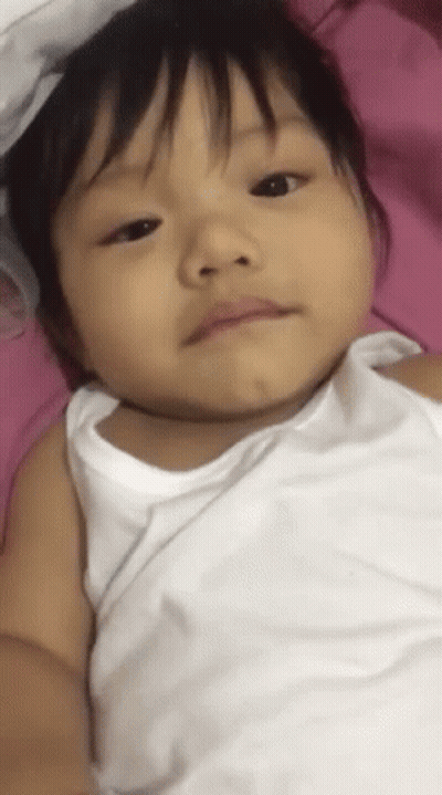 Girl In White Tank Top Lying On Pink Blanket GIF