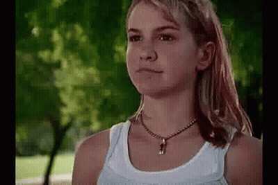 Girl In White Tank Top Standing In Park GIF