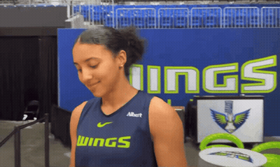 Girl In Wings Jersey In Front Of Blue Wall GIF