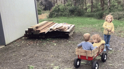 Girl In Yellow Sweater Pulling Wagon GIF