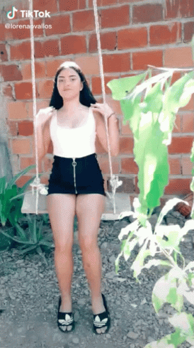 Girl On Swing By Brick Wall GIF