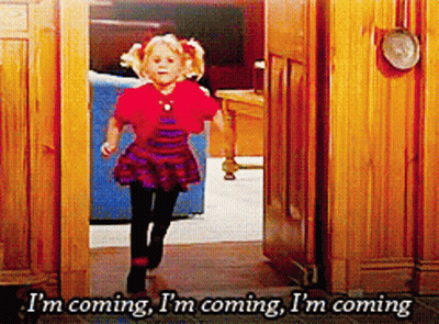 Girl Running Through Doorway Saying Im Coming GIF