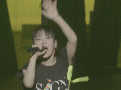 Girl Singing Into Microphone In SGN Shirt GIF