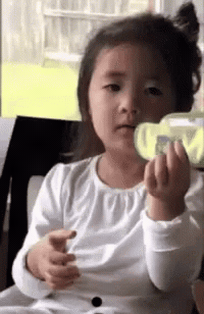 Girl Sitting In Chair Holding Green Object GIF