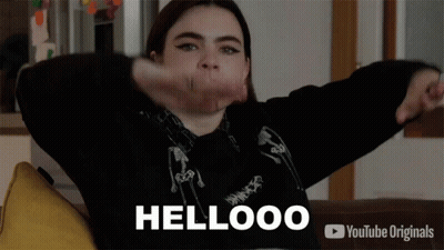 Girl Sitting On Couch Arms Outstretched Saying Hellooo GIF