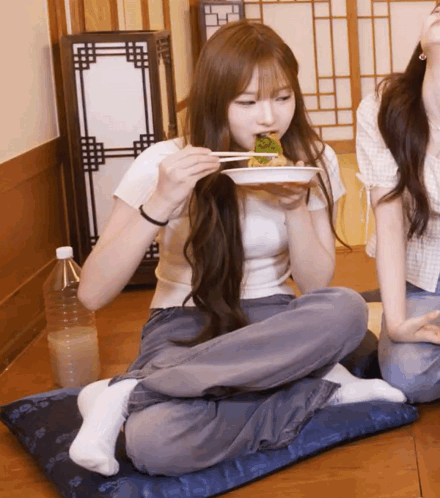 Girl Sitting On Pillow Eating Food With Chopsticks GIF