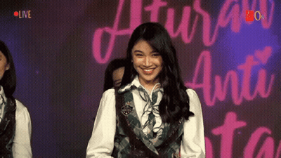 Girl Smiling At Sign Saying Live GIF