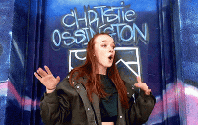 Girl Standing In Front Of Christie Ossington Wall GIF