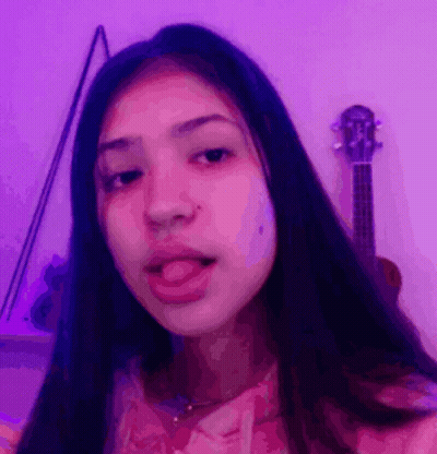 Girl Sticking Tongue Out By Purple Wall With Guitar GIF