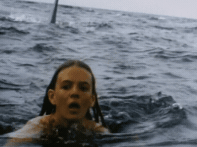 Girl Swimming In Ocean Behind Shark GIF