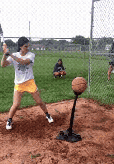Girl Swinging Bat At Basketball On Tee GIF