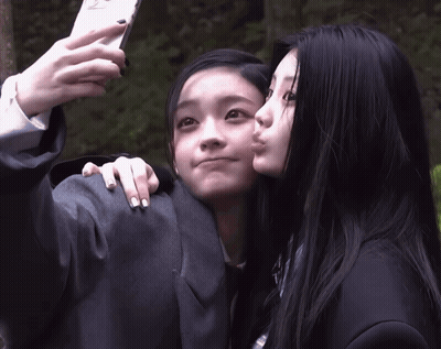 Girl Taking Selfie With Kiss On Cheek GIF