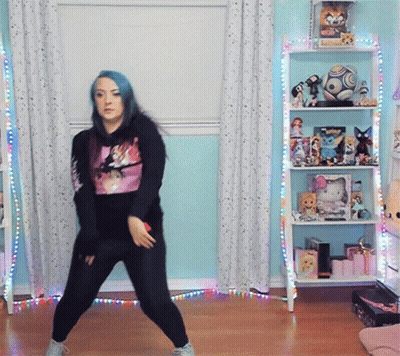 Girl With Blue Hair Dancing In Front Of Shelf With Soccer Ball GIF
