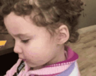 Girl with Curly Hair in Pink and Purple Sweater