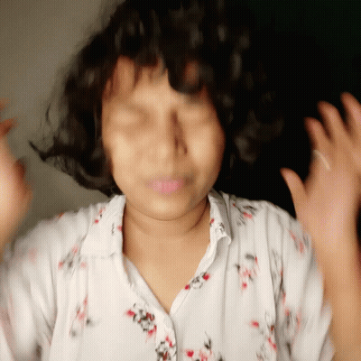 Girl With Curly Hair In White Shirt With Red Flowers GIF