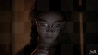 Girl With Glasses Looking In Dark Room GIF