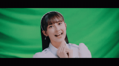 Girl With Headband Smiling In Front Of Green Screen GIF