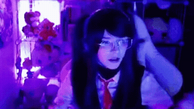 Girl With Headphones And Glasses At Computer In Dark Room GIF