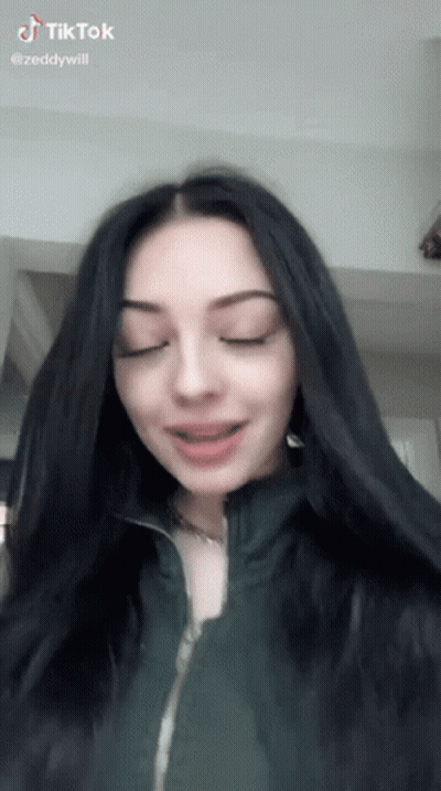 Girl With Long Black Hair In Green Jacket Making Funny Face GIF
