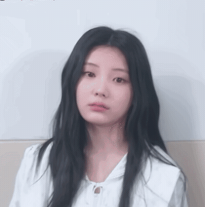 Girl With Long Black Hair In White Shirt Looking At Camera GIF