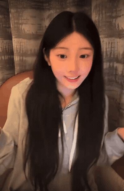 Girl With Long Dark Hair Smiling in Grey Hoodie