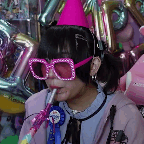 Girl With Pink Glasses And Party Hat Blowing Horn GIF