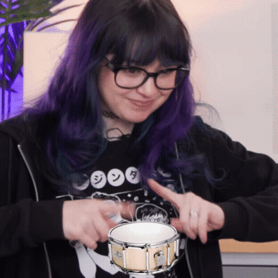 Girl With Purple Hair And Glasses Holding Drum GIF