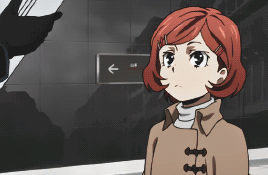 Girl With Red Hair Standing In Front Of Sign Pointing Left GIF