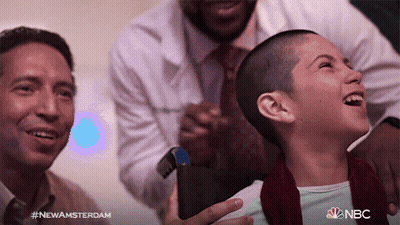 Girl With Shaved Head Laughing Held By Two Men NBC Logo GIF