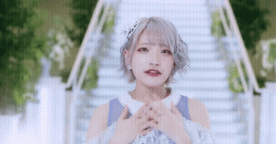Girl With Short Hair Standing On Stairs Hands Folded GIF