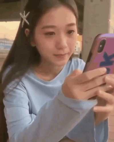 Girl With Starfish In Hair Looking At Cell Phone GIF