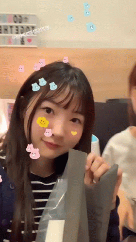 Girl With Stickers Holding Paper Smiling GIF