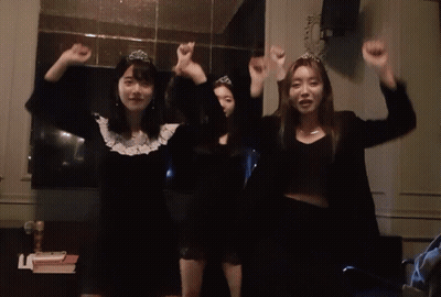 Chica con tiara parada junto a dos chicas GIF