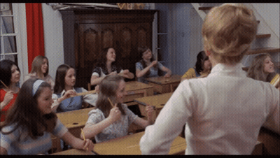 Girls Sitting At Desks In Classroom With Teacher GIF