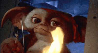 Gizmo Holding Knife With Flame In Mouth GIF
