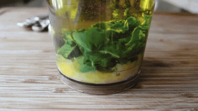 Glass With Green Leaves And Yellow Liquid GIF