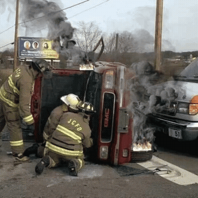 GMC Truck On Fire With Two Firefighters Kneeling GIF