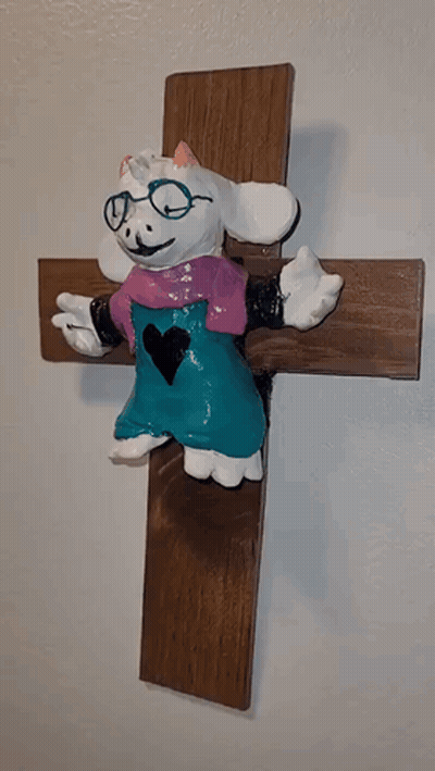 Goat Statue With Glasses Sitting On Cross GIF