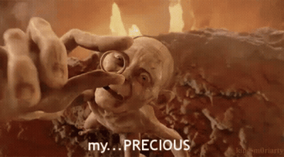 Gollum From The Lord Of The Rings Is Holding A Ring In His Hand And Says `` My Precious '' . GIF